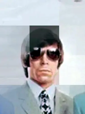 Man in a gray suit and sunglasses
